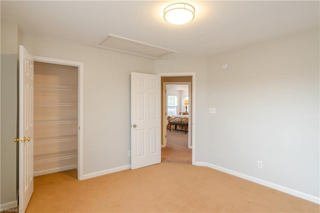 unfurnished bedroom with a closet and light colored carpet