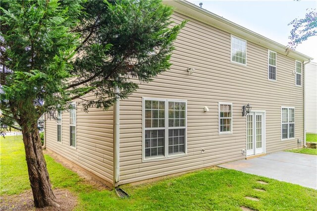 view of side of home featuring a patio and a yard