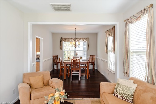 living room featuring an inviting chandelier and dark hardwood / wood-style flooring