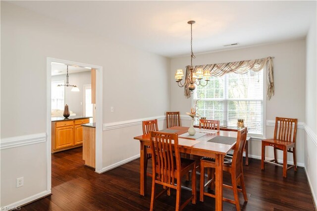 dining room featuring a chandelier and dark wood-type flooring