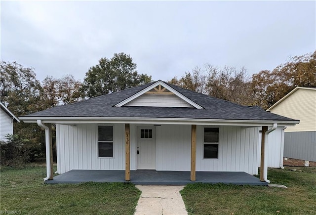 view of front of home with a porch, a front yard, and a shingled roof