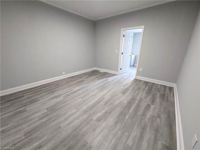 spare room featuring ornamental molding, wood finished floors, and baseboards