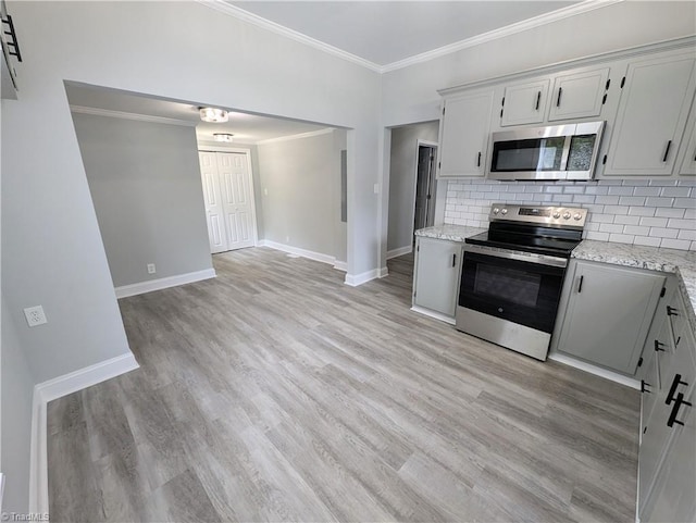 kitchen with backsplash, appliances with stainless steel finishes, ornamental molding, light wood-type flooring, and baseboards