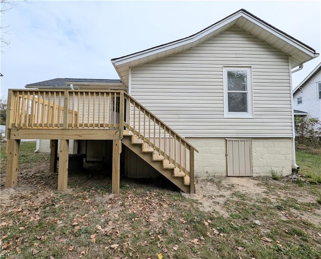 rear view of house featuring stairs and a deck