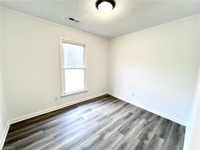 empty room featuring hardwood / wood-style flooring, crown molding, and a textured ceiling