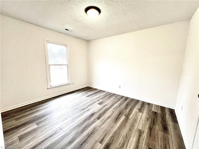 spare room with hardwood / wood-style floors and a textured ceiling