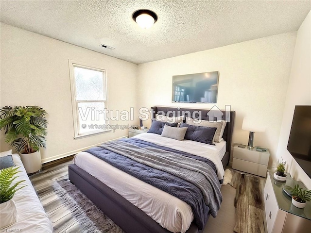 bedroom featuring dark wood-type flooring and a textured ceiling