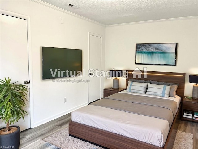 bedroom with hardwood / wood-style floors, crown molding, and a textured ceiling