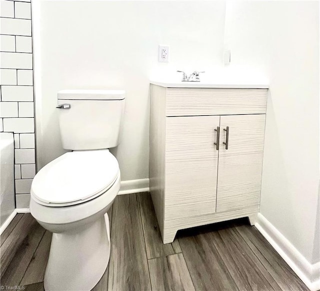 bathroom featuring vanity, hardwood / wood-style floors, and toilet