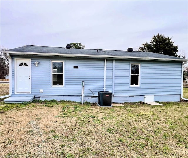 rear view of property featuring a yard and central AC