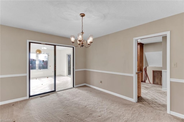 unfurnished room with carpet floors, a textured ceiling, and a chandelier