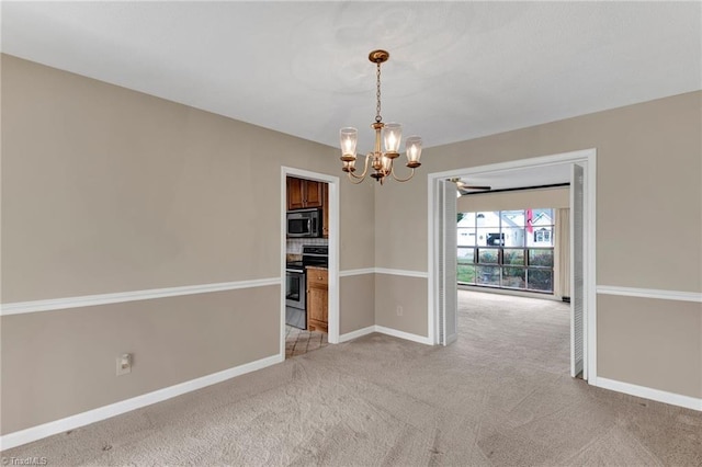 carpeted empty room featuring a notable chandelier