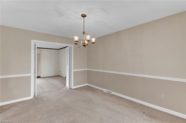 spare room with carpet flooring and an inviting chandelier