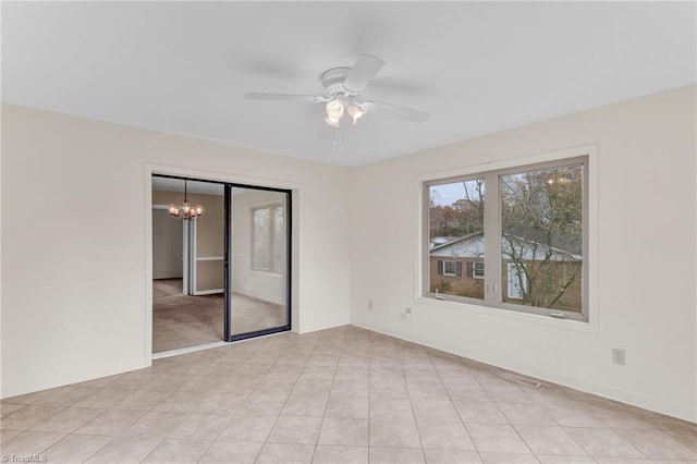 unfurnished room with ceiling fan with notable chandelier