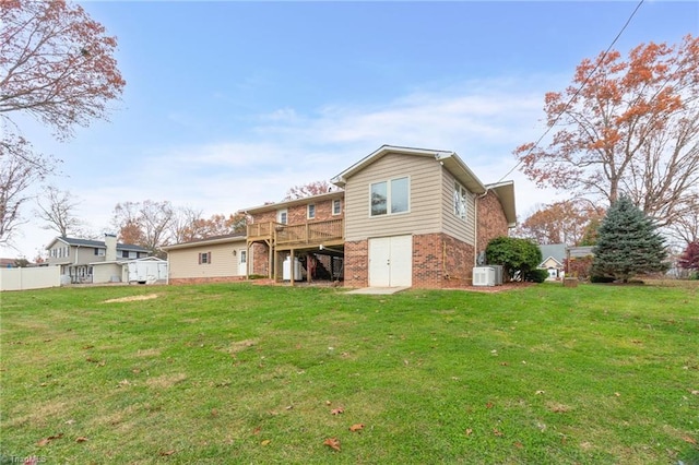 rear view of property featuring a lawn and a wooden deck