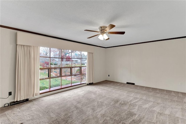 carpeted empty room featuring a textured ceiling, ceiling fan, and ornamental molding