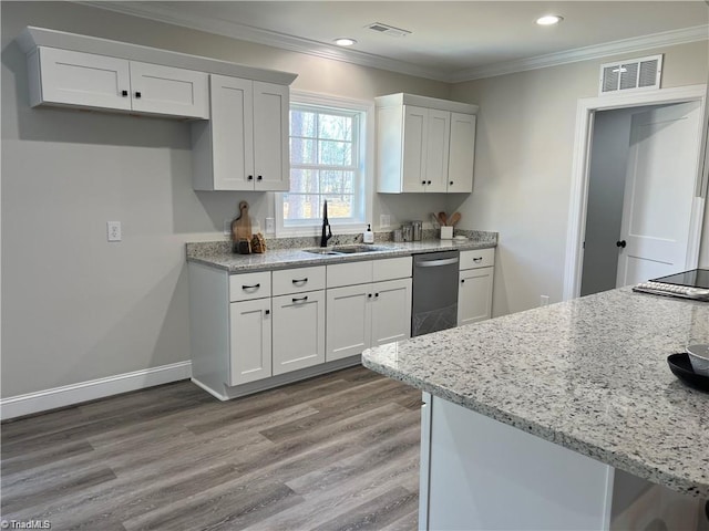 kitchen featuring light stone counters, white cabinetry, stainless steel dishwasher, light wood-type flooring, and sink