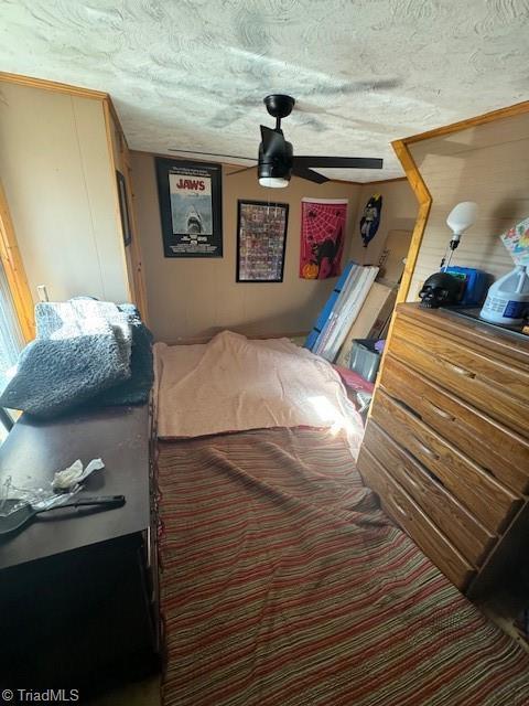 bedroom with ceiling fan and a textured ceiling