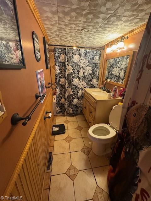 bathroom featuring toilet, visible vents, ornamental molding, and vanity