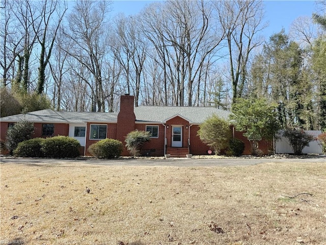 ranch-style home featuring crawl space, brick siding, a chimney, and a front yard