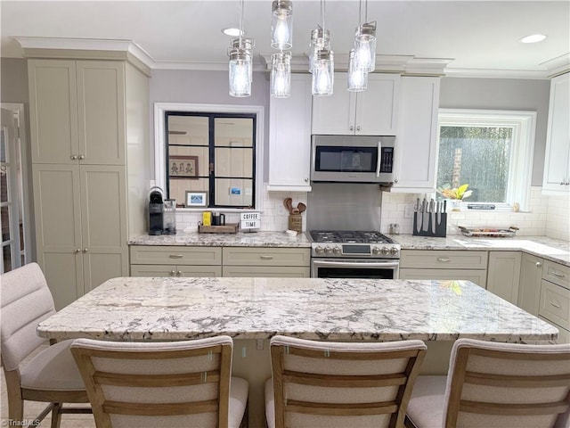 kitchen with appliances with stainless steel finishes, a breakfast bar, crown molding, and light stone counters