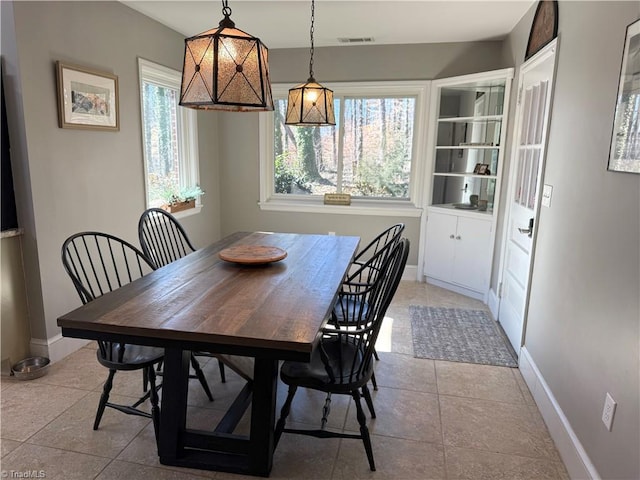 dining space with light tile patterned floors, visible vents, and baseboards