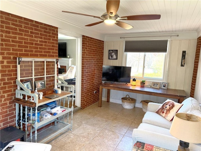 living area with wooden ceiling, brick wall, ceiling fan, crown molding, and a fireplace