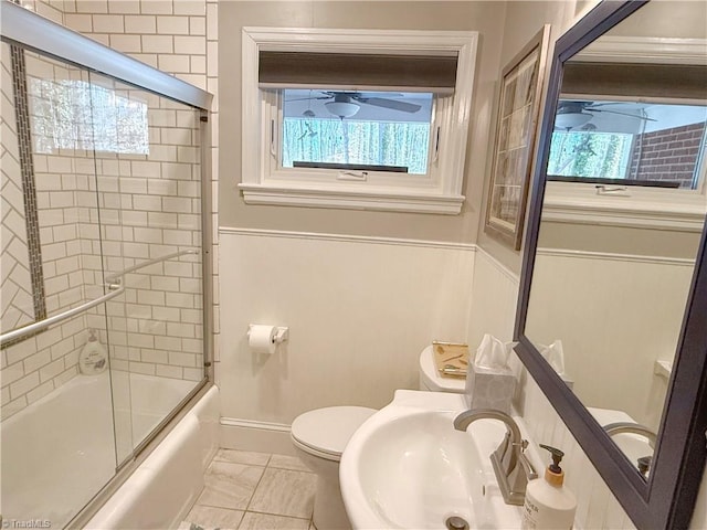 full bath with toilet, plenty of natural light, bath / shower combo with glass door, and a sink