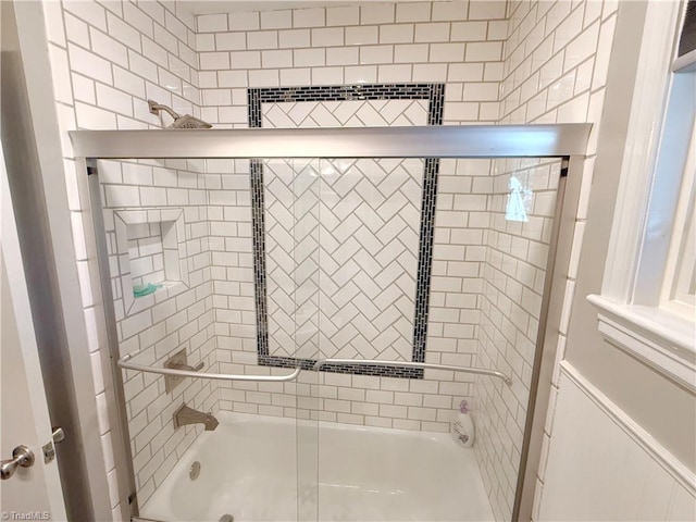 bathroom featuring bath / shower combo with glass door