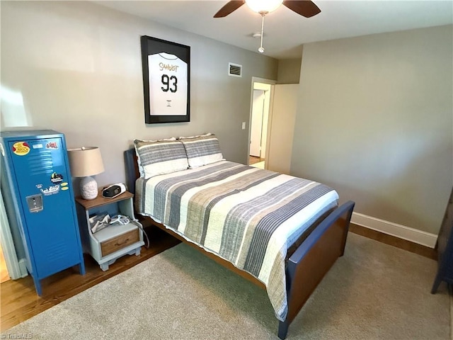 bedroom featuring visible vents, ceiling fan, baseboards, and wood finished floors