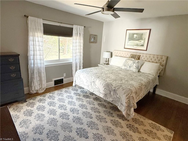 bedroom with a ceiling fan, wood finished floors, visible vents, and baseboards