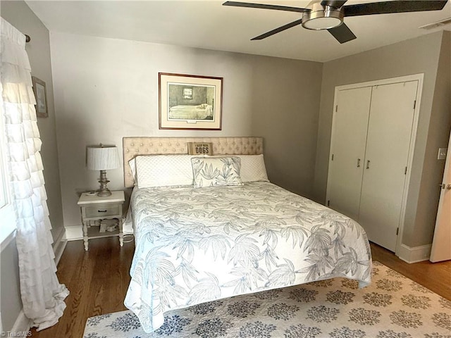 bedroom with dark wood-type flooring, a closet, visible vents, and a ceiling fan