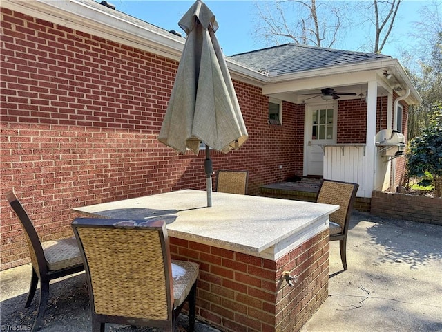 view of patio featuring a ceiling fan and a bar