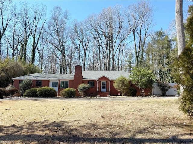 ranch-style house with crawl space, a front lawn, a chimney, and brick siding