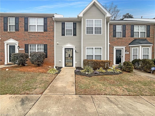 townhome / multi-family property featuring a front yard