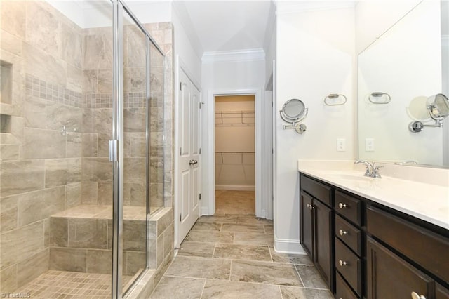 bathroom featuring ornamental molding, a shower with door, and vanity