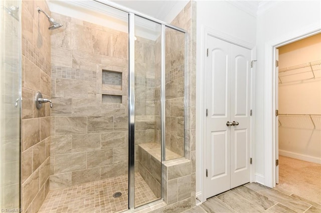 bathroom with crown molding and an enclosed shower