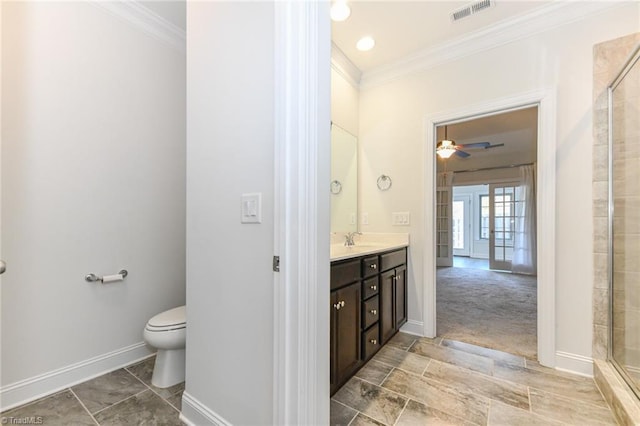 bathroom featuring toilet, crown molding, ceiling fan, a shower with shower door, and vanity