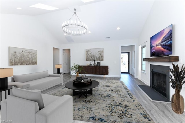 living room featuring wood-type flooring, high vaulted ceiling, and an inviting chandelier