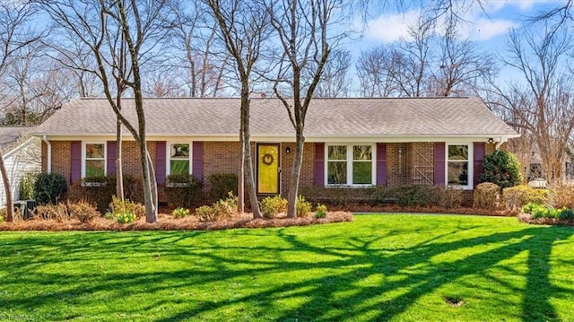 ranch-style house with a front lawn and brick siding