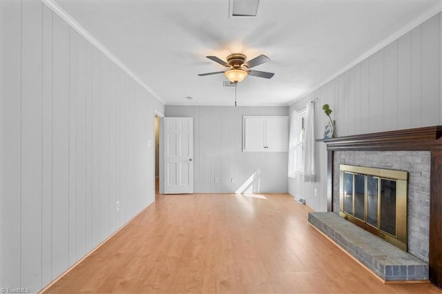 unfurnished living room with visible vents, crown molding, ceiling fan, a fireplace, and wood finished floors