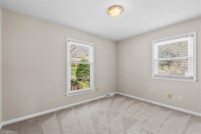 spare room featuring visible vents, baseboards, and carpet floors