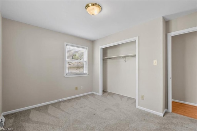 unfurnished bedroom with carpet flooring, baseboards, and a closet