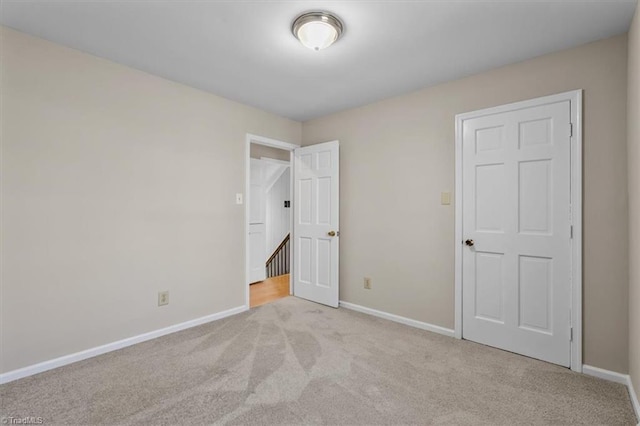 unfurnished bedroom with carpet flooring and baseboards