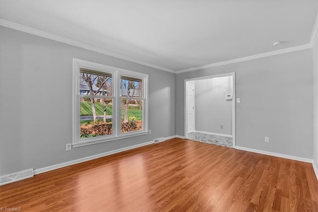 unfurnished room with wood finished floors, visible vents, and baseboards