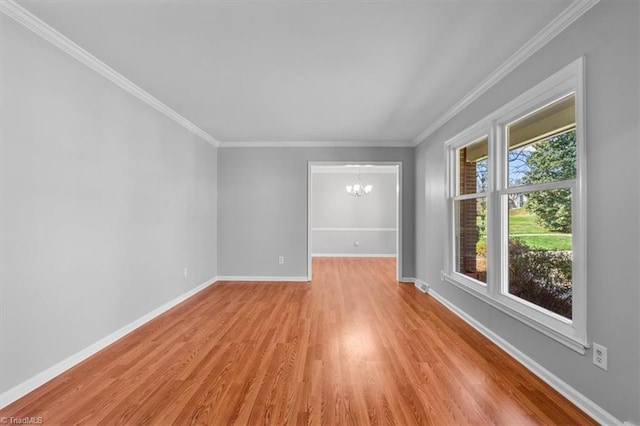 unfurnished room featuring a notable chandelier, baseboards, light wood finished floors, and ornamental molding