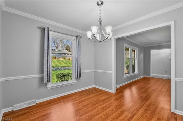 unfurnished dining area featuring visible vents, plenty of natural light, baseboards, and wood finished floors