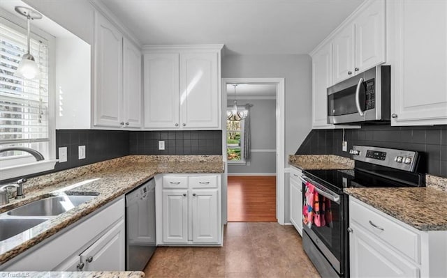 kitchen featuring a sink, decorative backsplash, appliances with stainless steel finishes, and white cabinets