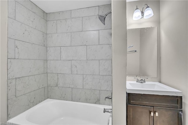 bathroom featuring vanity and tiled shower / bath