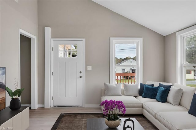 living room featuring light hardwood / wood-style floors and vaulted ceiling